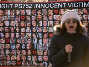 A protester chants in front of a poster with the faces of the victims of Ukraine International Airlines Flight PS752 in Ottawa