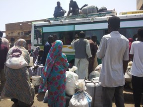 People board a bus to leave Khartoum, Sudan