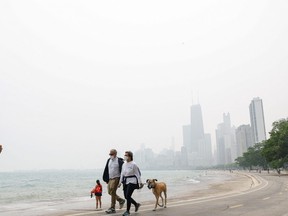 People walk and jog along the shoreline of Lake Michigan