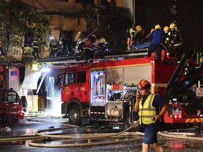 , firefighters work at the site of an explosion at a restaurant
