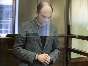 Vladimir Kara-Murza stands in a glass cage in a courtroom at the Moscow City Court