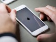 An employee works on reconditioning an iPhone at a refurbishing company, in Sainte-Luce-sur-Loire, outside Nantes, France, Jan. 26, 2021.