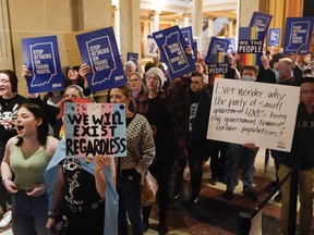 Protesters stand outside of the Senate chamber at the Indiana Statehouse