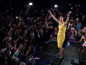 Olivia Chow on stage, arms in the air