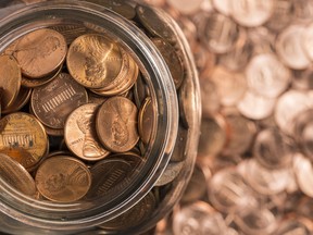 A jar of pennies surrounded by pennies.