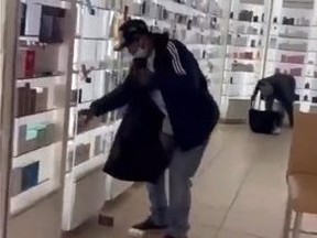 Thieves emptying shelves in store's beauty section.