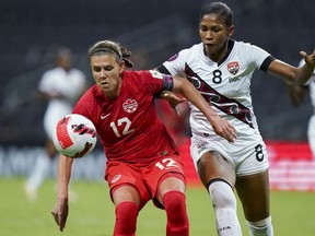 Canada's Christine Sinclair (left) and Trinidad and Tobago's Victoria Swift compete for the ball