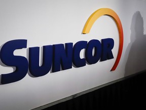 A Suncor logo is shown at the company's annual meeting in Calgary, Thursday, May 2, 2019. Suncor on Thursday said is would lay off 1,500 workers by the end of 2023.