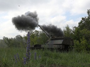 Ukrainian servicemen fire a 155mm self-propelled howitzer