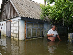 Yuriy, a 56-year-old Ukrainian farmer stands chest-deep in water
