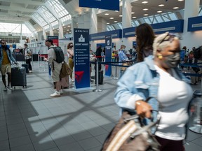 People travel through the terminal at John F. Kennedy Airport at the start of the Memorial Day weekend on May 27, 2022 in New York City