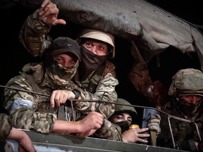 Members of Wagner group looks from a military vehicle in Rostov-on-Don