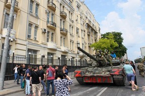 Members of Wagner group sit atop of a tank in a street in the city of Rostov-on-Don