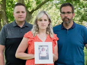 Brent Campbell, Alicia Guthrie and Joel Campbell, the children of Fenny Campbell, hold a photo of their mother, who was murdered by their father Donald Campbell in 1997. (Lynette Brown photo)
