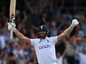 England's Mark Wood celebrates after Woakes hits a boundary to win the match.