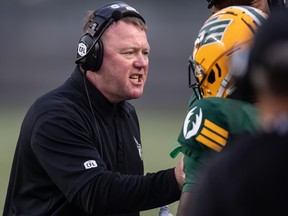Edmonton Elks head coach Chris Jones speaks to a player while taking on the Hamilton Tiger-Cats.