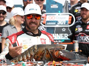 Martin Truex Jr., driver of the #19 Reser's Fine Foods Toyota, is presented Loudon the Lobster.