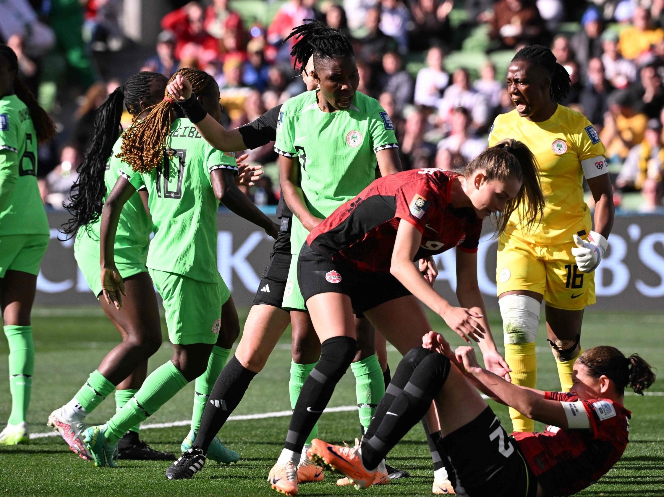 Canada forward Christine Sinclair reacts on the ground after missing a penalty as Nigeria's goalkeeper Chiamaka Nnadozie celebrates.