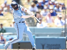 Whit Merrifield of the Toronto Blue Jays hits a three-run home run against the Los Angeles Dodgers.