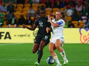Ireland midfielder Katie McCabe (R) and Nigeria forward Uchenna Kanu fight for the ball.