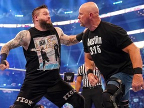 WWE superstar Kevin Owens, left, battles WWE hall of famer Stone Cold Steve Austin at WrestleMania 38 in Dallas, Texas.