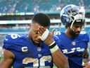 Saquon Barkley, left, and Darius Slayton of the New York Giants leave the field after the game against the Miami Dolphins at Hard Rock Stadium on Dec. 5, 2021, in Miami Gardens, Fla. 