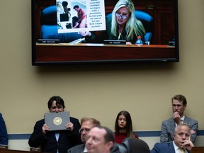 People watch as U.S. Representative Marjorie Taylor Greene (R-GA) holds up a graphic photo of Hunter Biden during the House Committee on Oversight and Accountability hearing regarding the criminal investigation into the Bidens, on Capitol Hill in Washington, DC, on July 19, 2023.