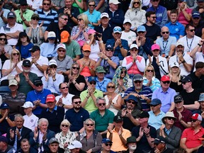 Spectators on a stand react to a shot on the 17th green on day one of the 151st British Open Golf Championship at Royal Liverpool Golf Course in Hoylake, north west England on July 20, 2023.