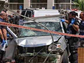Members of Israeli security and emergency personnel work at the site of a reported car ramming attack in Tel Aviv on July 4, 2023.