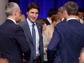 Canada's Prime Minister Justin Trudeau (C) talks with NATO Secretary General Jens Stoltenberg