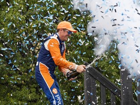 Scott Dixon of New Zealand celebrates with champagne in the winners circle after winning the 2022 Honda Indy Toronto, in Toronto, Sunday, July 17, 2022.