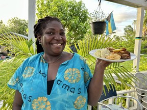 Colette Williams holds up a plate of home cooking she prepared for some Canadian guests.