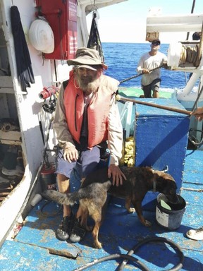 In this photo provided by Grupomar/Atun Tuny, Australian Tim Shaddock sits with his dog Bella after being rescued by a Mexican tuna boat in international waters, after being adrift with his dog for three months.