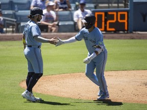 Blue Jays' Whit Merrifield, right, celebrates his three-run home run with Bo Bichette during the fifth inning against the Los Angeles Dodgers in Los Angeles, Wednesday, July 26, 2023.