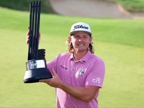 Cameron Smith of Australia poses with the trophy after his win on day three of LIV Golf - London