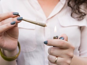 A woman lights a marijuana cigarette.