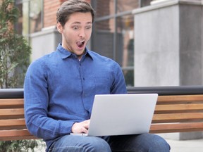 Young Man in Shock Working on Laptop