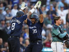 National League's Elias Díaz, of the Colorado Rockies (right), celebrates his two-run home run with Nick Castellanos of the Philadelphia Phillies, in the 8th inning during the MLB All-Star baseball game in Seattle Tuesday night. (AP Photo/Lindsey Wasson)