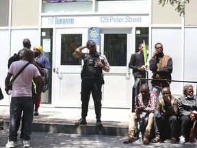 African refugees outside the Peter St. city-run facility for homeless in Toronto on Thursday July 13, 2023.