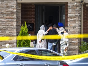 People arrive at a house and embrace as Peel Regional Police work at the scene at a house across the street on Argelia Cres. in Brampton on Tuesday, July 25, 2023.