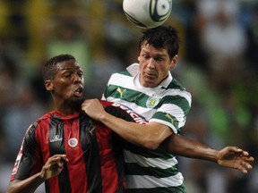Sporting's Brazilian defender Anderson Polga (right) vies with Olhanense's Mozambican defender Mexer (left) during the Portuguese league football match Sporting Lisbon vs Olhanense at the Alvalade Stadium in Lisbon on Aug. 13, 2011.