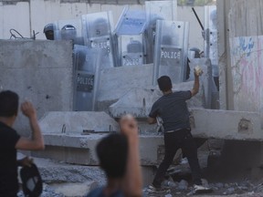 Iraqis throw stones during clashes with security forces