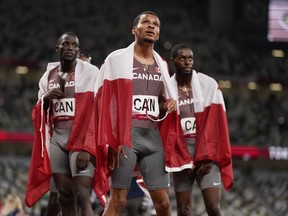 Andre De Grasse, of Canada, centre, stands with teammates after getting the bronze in the final of the men's 4 x 100-metre relay at the 2020 Summer Olympics, in Tokyo, Friday, Aug. 6, 2021. The Canadian Olympic Committee announced Monday that the team will receive their upgraded Olympic silver medals on Saturday at the Canadian national trials in a medal reallocation ceremony.