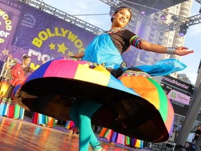 Woman dancing on stage in colourful costume.