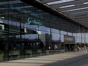 Passengers walk into the Departures entrance at the North Terminal of Gatwick Airport near Crawley, just south of London