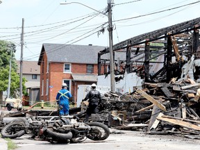 Motorcycles recovered from an Outlaws clubhouse lie in the foreground Tuesday