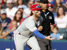 Bryce Harper of the Philadelphia Phillies throws out Steven Kwan of the Cleveland Guardians at first base during the first inning