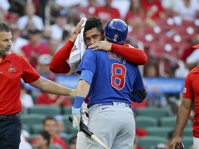 St. Louis Cardinals catcher Willson Contreras embraces Chicago Cubs' Ian Happ as Contreras leaves the game after being hit by Happ's bat during the first inning of a baseball game Thursday, July 27, 2023, in St. Louis.