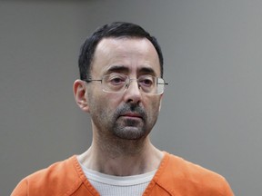 FILE - Disgraced former sports doctor Larry Nassar appears in court for a plea hearing, Nov. 22, 2017, in Lansing, Mich. Women sexually assaulted by imprisoned former Michigan State University sports doctor Larry Nassar have filed a lawsuit, Thursday, July 27, 2023, claiming school officials made "secret decisions" about releasing documents in the case.