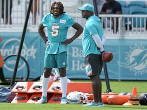 Miami Dolphins cornerback Jalen Ramsey (5) stands with a member of the coaching staff during practice at the NFL football team's training facility, Thursday, July 27, 2023, in Miami Gardens, Fla.